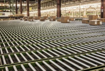 Interior view of a gravity feed conveyor system in a large distribution warehouse with products