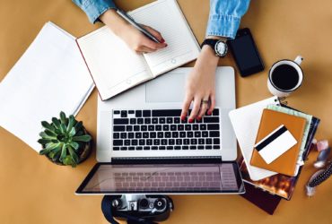 stylish young girl working economist financial analytics holding pen with laptop