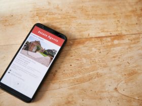 Close Up Of Mobile Phone With Realtors Property App Lying On Table